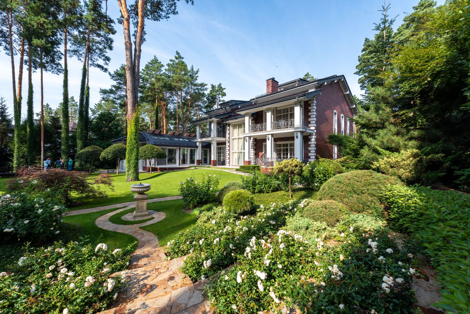 Paisajismo de jardín residencial con senderos y especies vegetales
